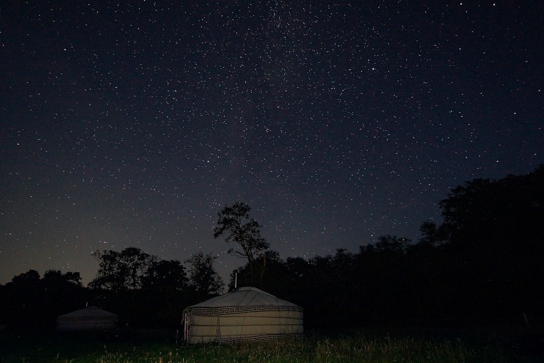 Photo by Sebastian Marx a tent in a field at night