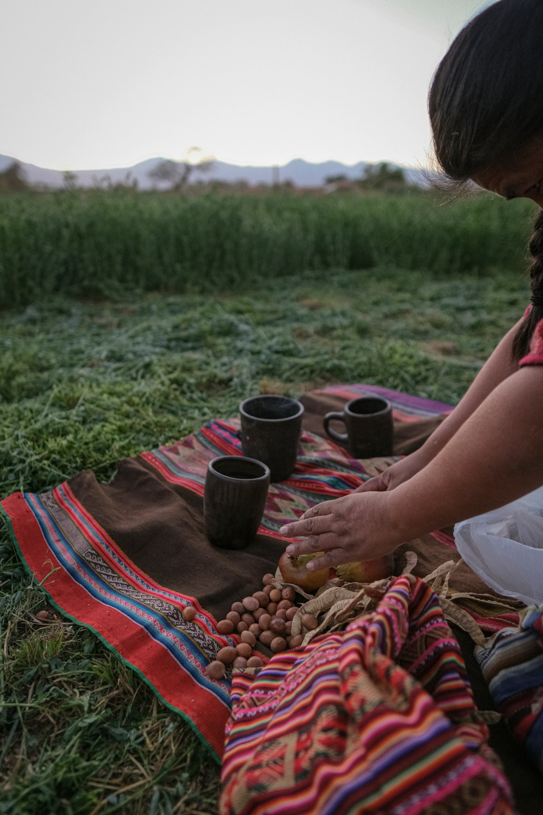Woman prepares food and drinks outdoors.